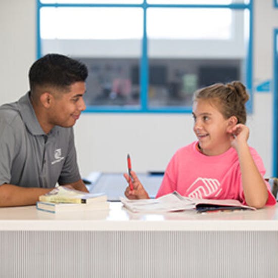 A BGCSC member receives help with her homework at an after-school program