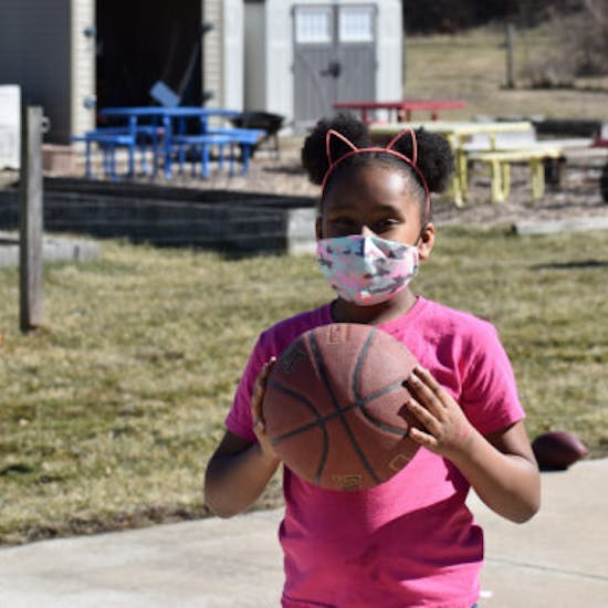 A girl plays basketball at an after-school program